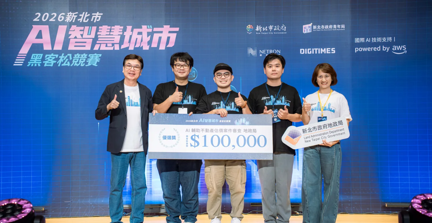 Award ceremony of the 2026 New Taipei AI Smart City Hackathon — team AI城市起風 on stage with city officials, holding the NT$100,000 Land Office track winner board