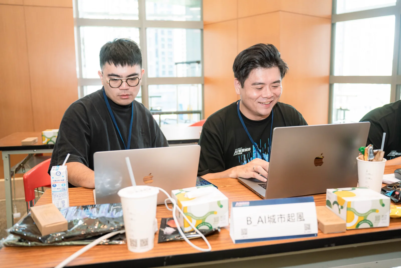 Team AI城市起風 at their desk in the competition hall, team name card on the table